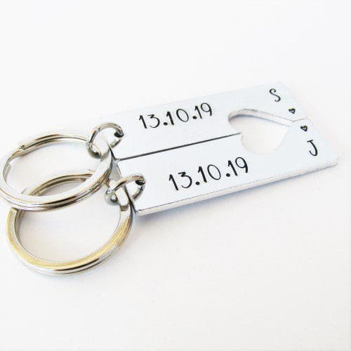 a set of 2 rectangle keyrings with a heart cut-out featuring personalised anniversary dates and initials
