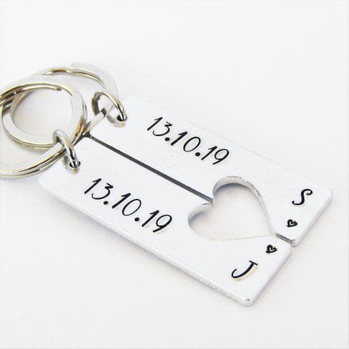 a set of 2 rectangle keyrings with a heart cut-out featuring personalised anniversary dates and initials