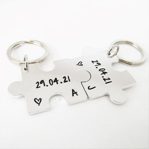 a set of 2 interlocking puzzle shaped keyrings featuring personalised anniversary dates and initials
