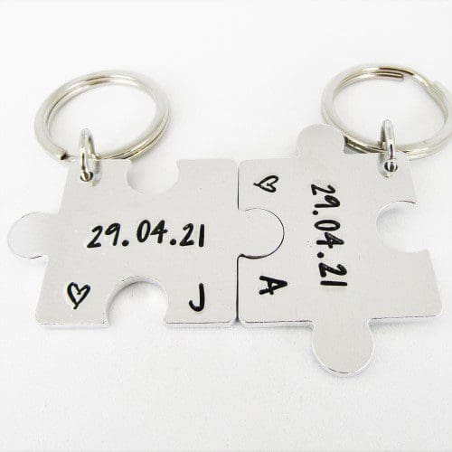 a set of 2 interlocking puzzle shaped keyrings featuring personalised anniversary dates and initials