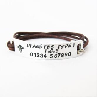 personalised hand stamped medical ID aluminium bar with a leather cord wrap-style bracelet