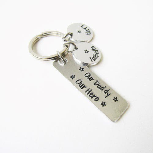 slim rectangular aluminium keyring with the eords 'our daddy, our hero' hand-stamped on it with personalised name tags attached