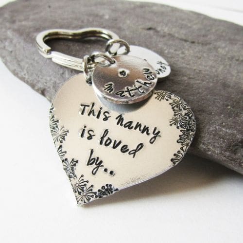 aluminium heart keyring hand-stamped with 'this Nanny is loved by' with flower detailing and personalised name tags