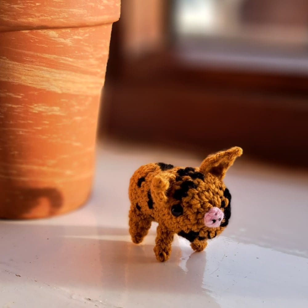 gold black spotted piglet on window sill