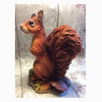 Realistic hand painted Red squirrel sculpture with Rowan leaves, confers and a toadstool around the base.