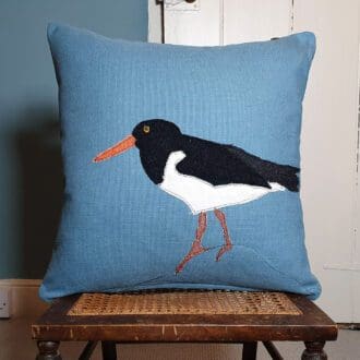 Oystercatcher cushion on blue cover