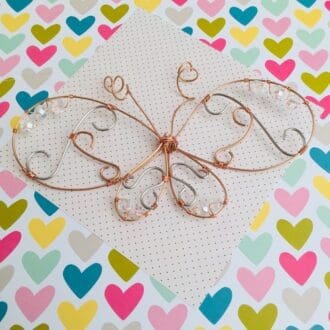 Butterfly hanging decoration made from wire with wire swirls inside the wings and clear crystal accent beads