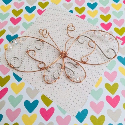 Butterfly hanging decoration made from wire with wire swirls inside the wings and clear crystal accent beads