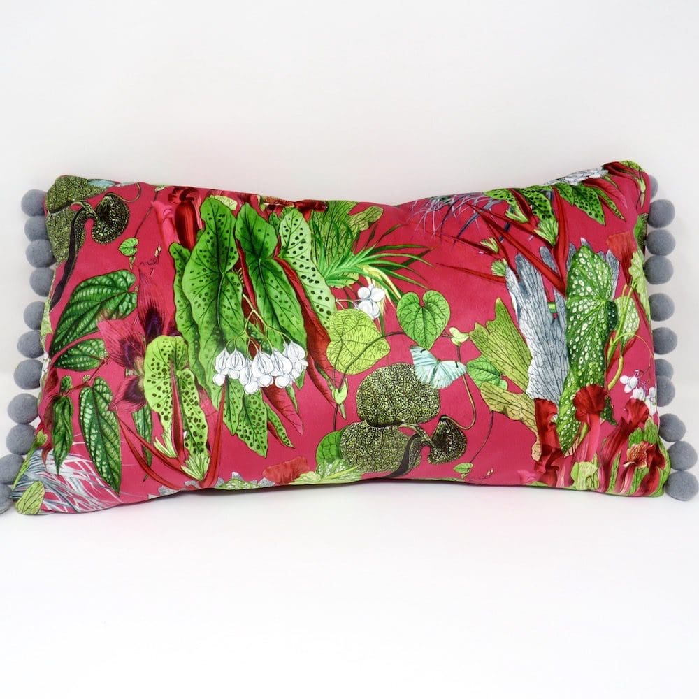Boudoir cushion handmade in a cerise and green print velvet, and with a grey pom pom trim