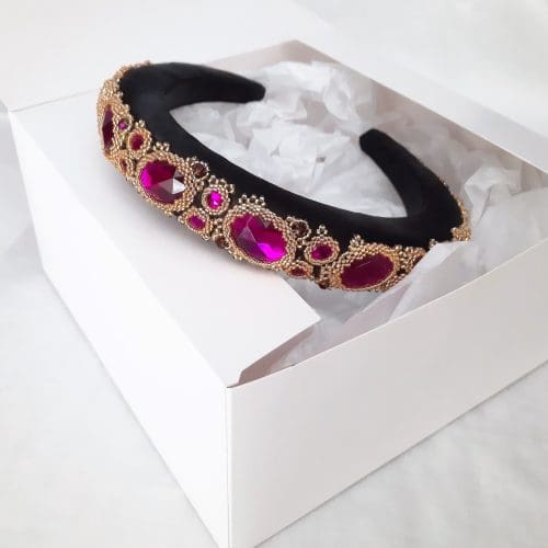 Black padded headbands with purple jewels set in gold bezels.