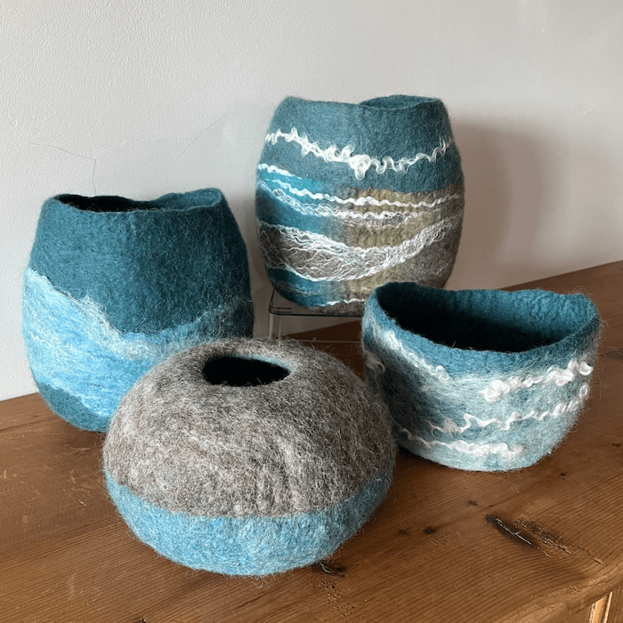 Four handmade felt vessels in coastal colours