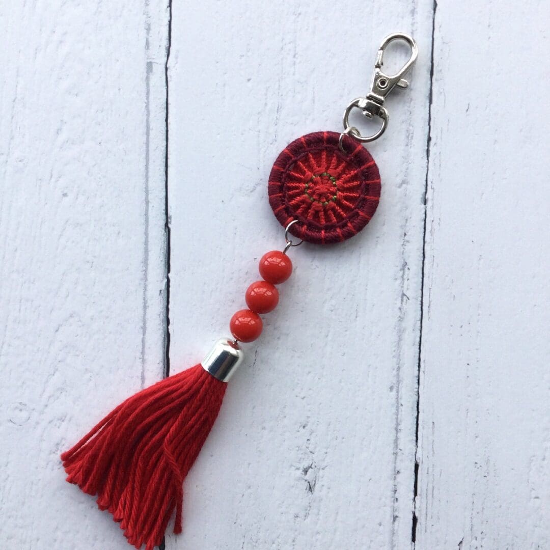 Red Dorset button withe tassel bag charm