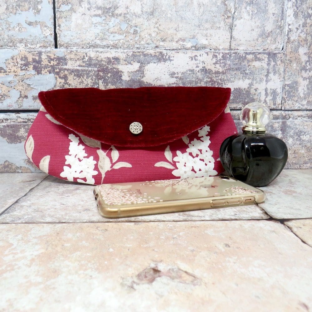 Handmade mini clutch or makeup bag in a raspberry coloured print