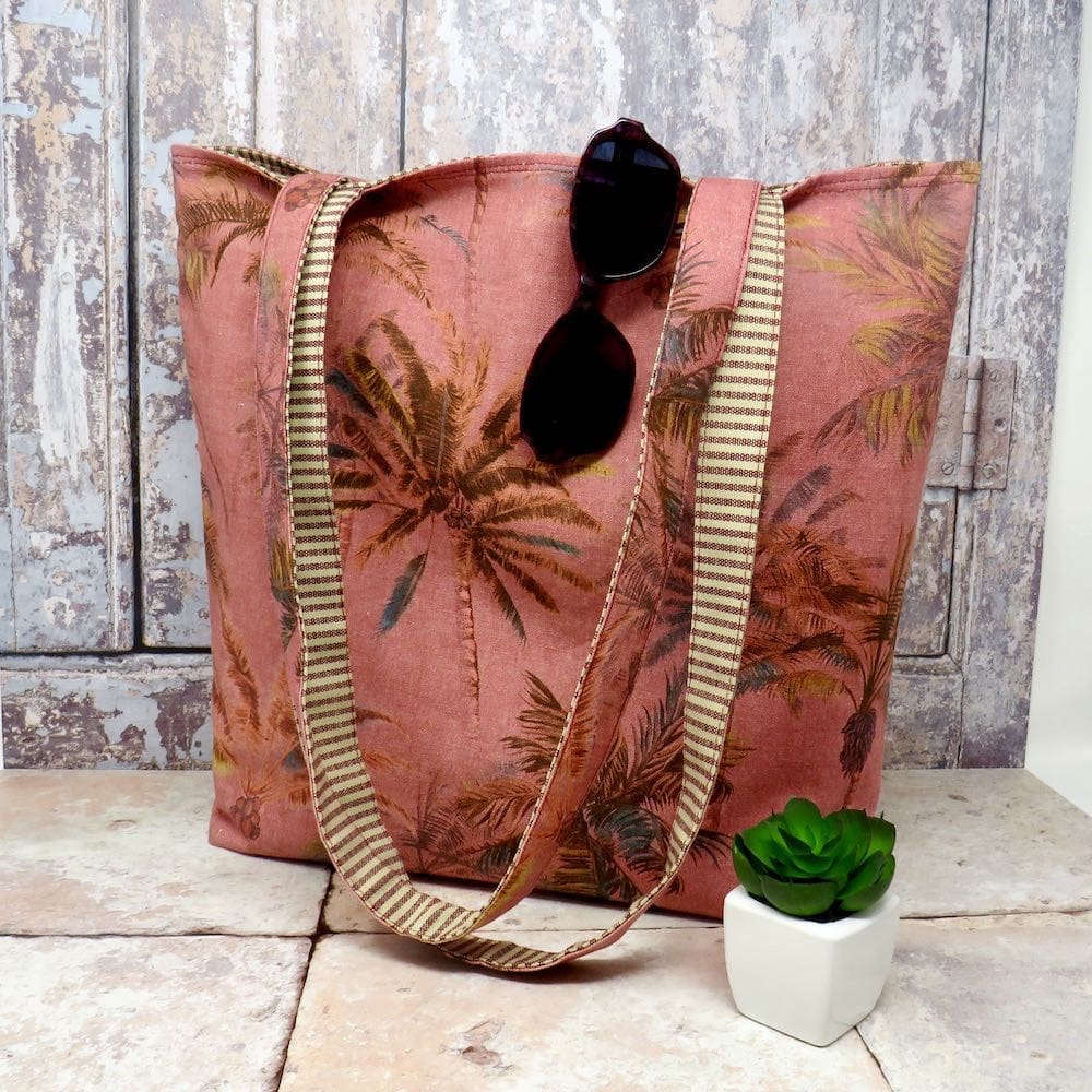 Reversible tote with a terracotta palm print on one side and a stripe on the other