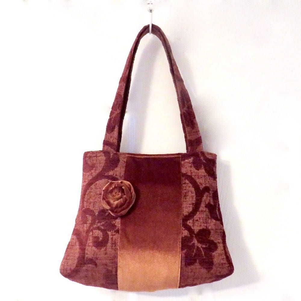 Handmade rust coloured handbag with a brooch trim