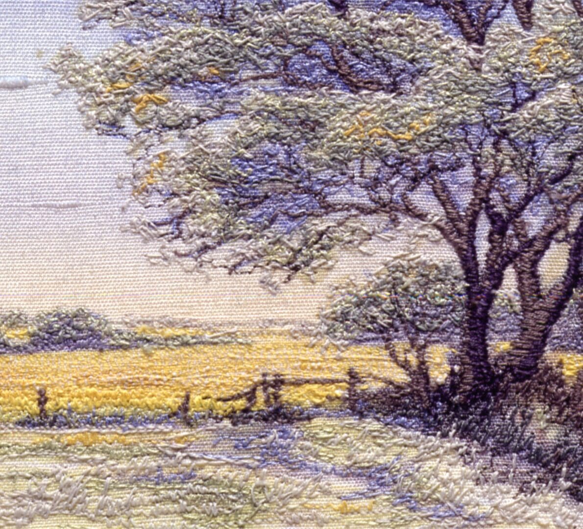 embroidered picture of a yellow spring landscape of oil seed rape and trees
