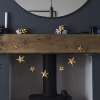 gold origami star garland hanging over fireplace