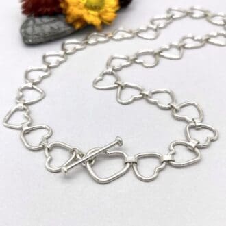 solid silver heart link chain necklace with larger heart and t-bar fastener