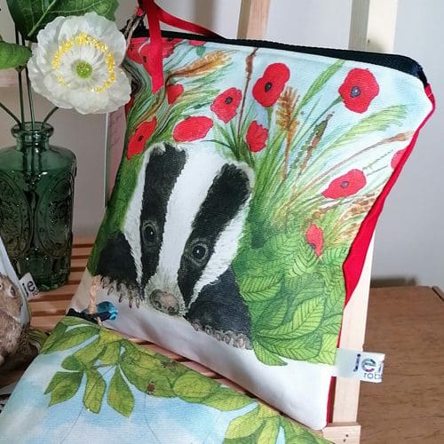 Cotton washbag with a young badger snuggled amongst the poppies. Red back with a chunky plastic zipper fastening with satin ribbon zip pull. Water resistant lining and internal pocket.