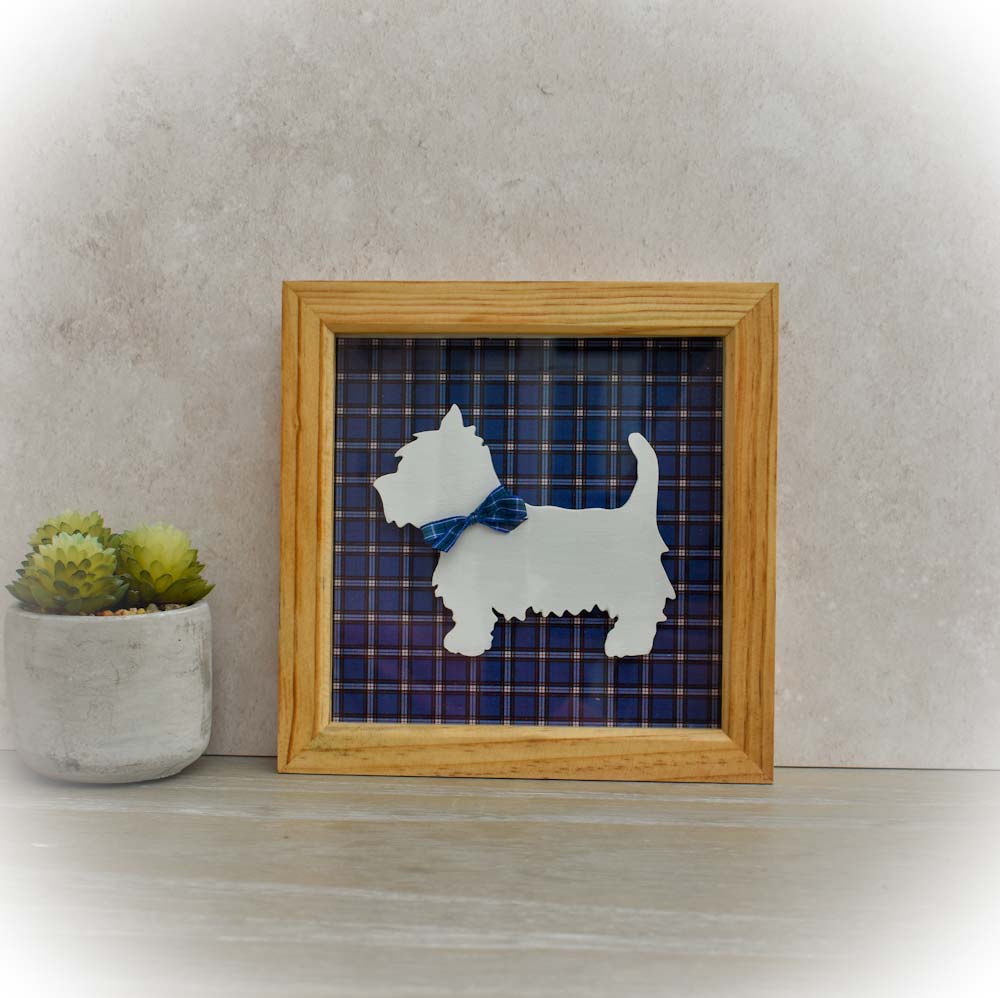 Wooden Box Frame containing a White West Highland Terrier with a blue tartan ribbon around his neck. Set against a blue tartan background.