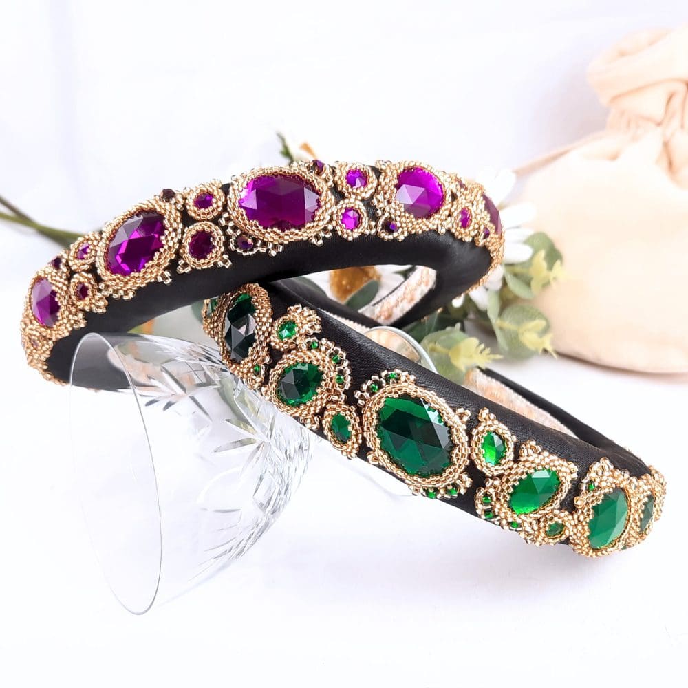 Black padded headbands with purple or green jewels set in gold bezels.