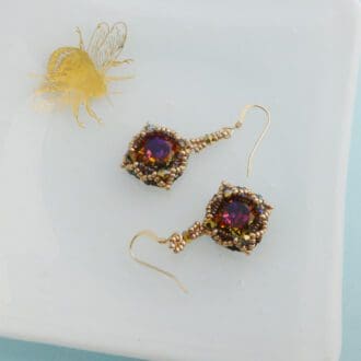 Handmade beaded drop earrings in shades of gold purple and blue