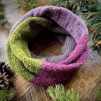 Knitted block colour infinity scarf in green, pink and taupe greys