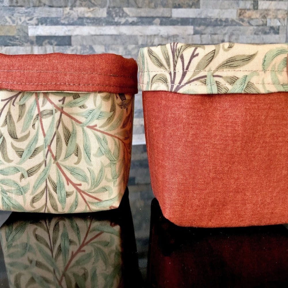 Reversible fabric pots in William Morris Willow design in green on a deep cream background and rich brown lining on a brick background