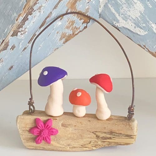 Miniature polymer clay toadstools set on driftwood wall hanger