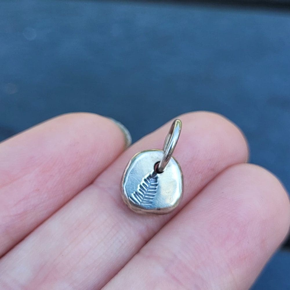 silver charm with pine tree