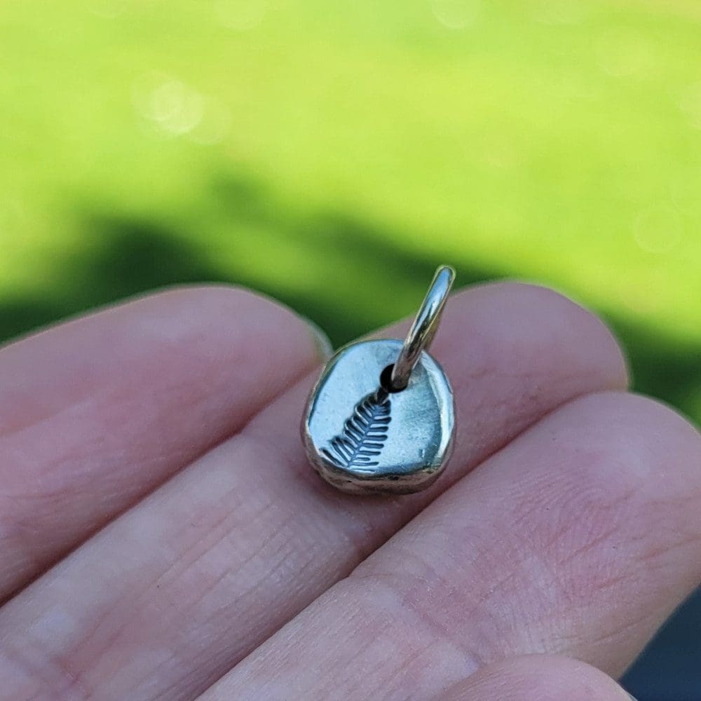 silver charm with pine tree