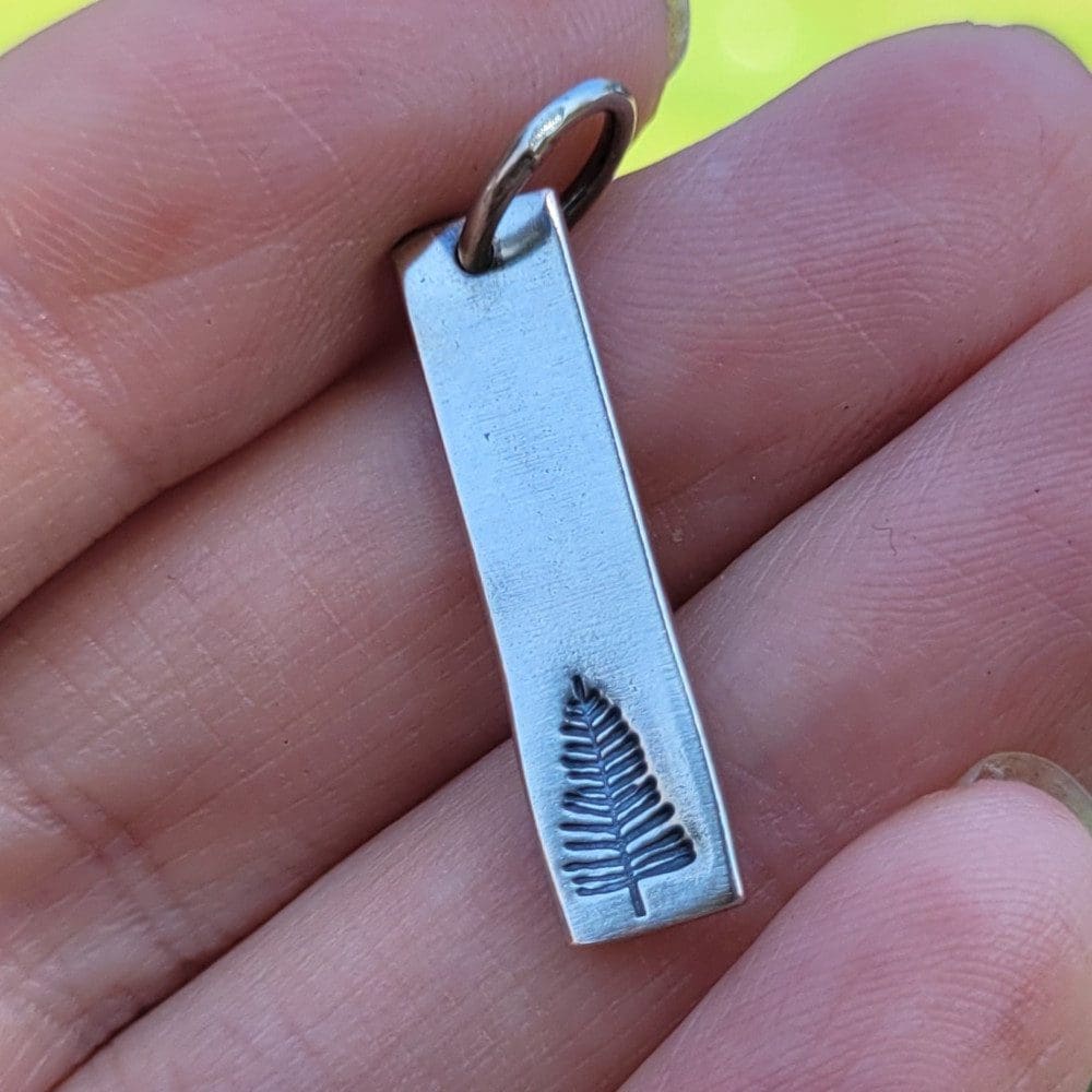 silver pendant with pine tree