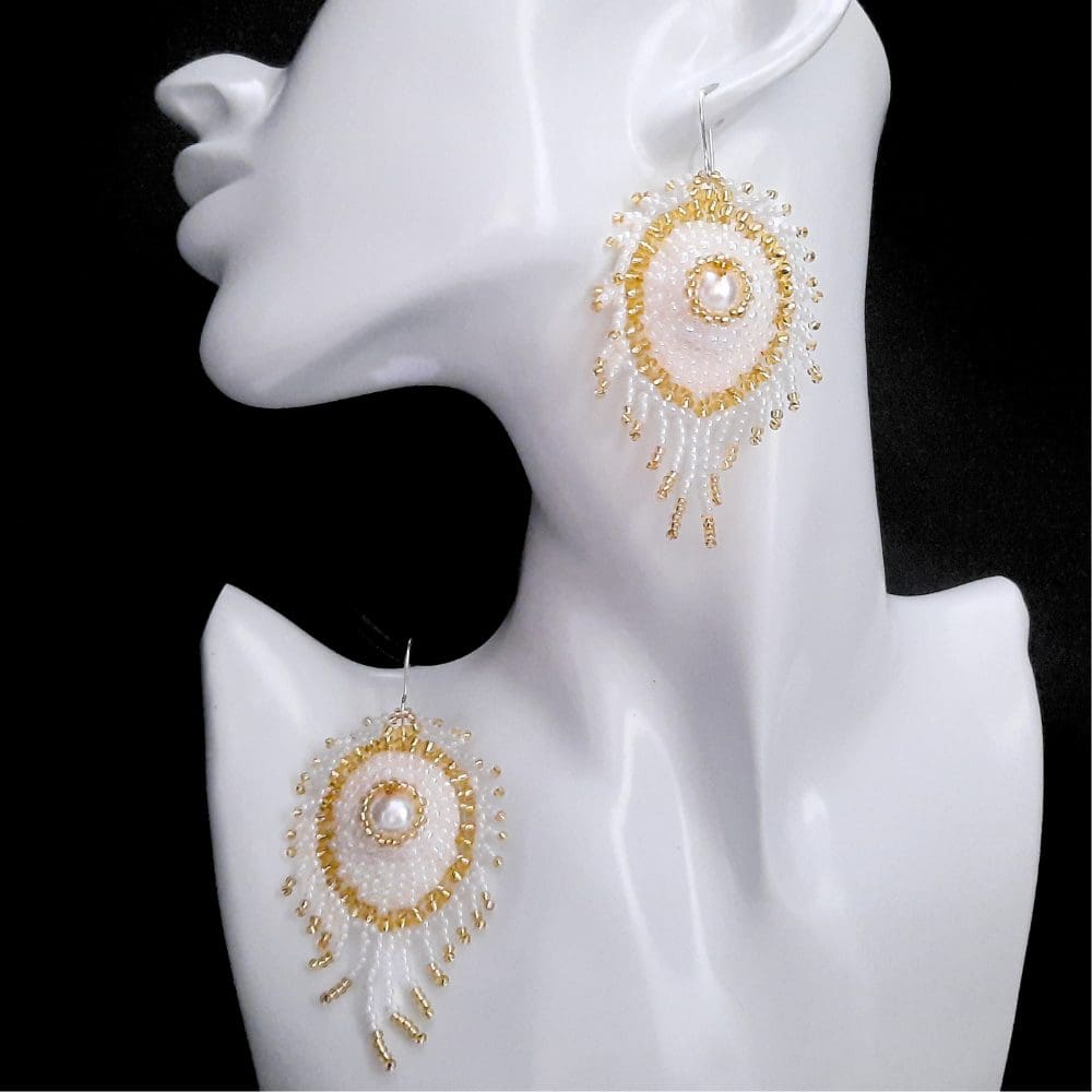 Beaded white coloured peacock feather earrings.
