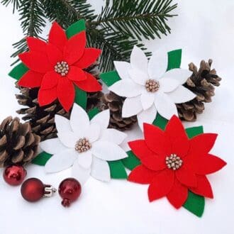 Red and white poinsettia pin backed brooches.