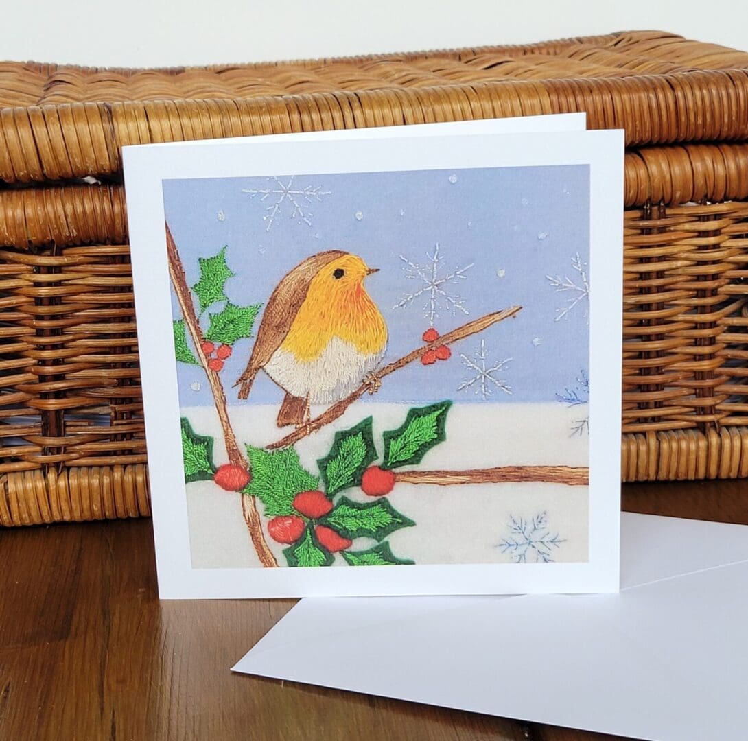 Robin sat amongst holly and snowflakes printed Christmas card 6 x 6 inches.