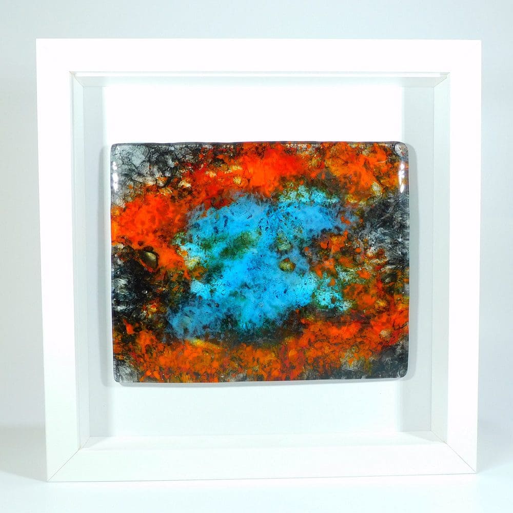 A framed piece of fused glass designed to look like a nebula in space