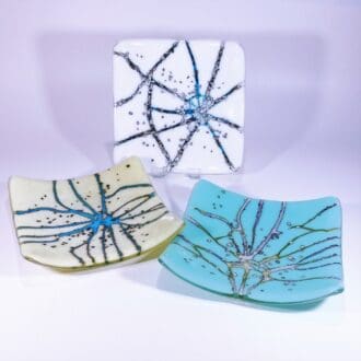 A collection of fused glass dishes made using coloured glass that reacts with each other creating interesting effects