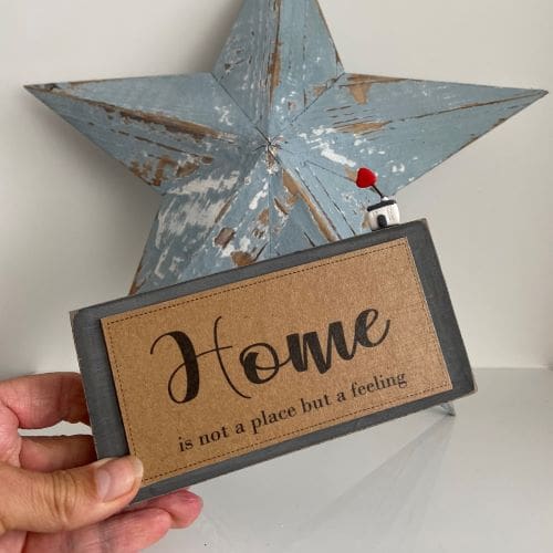 Handmade wooden sign with a miniature clay house - home is not a place but a feeling