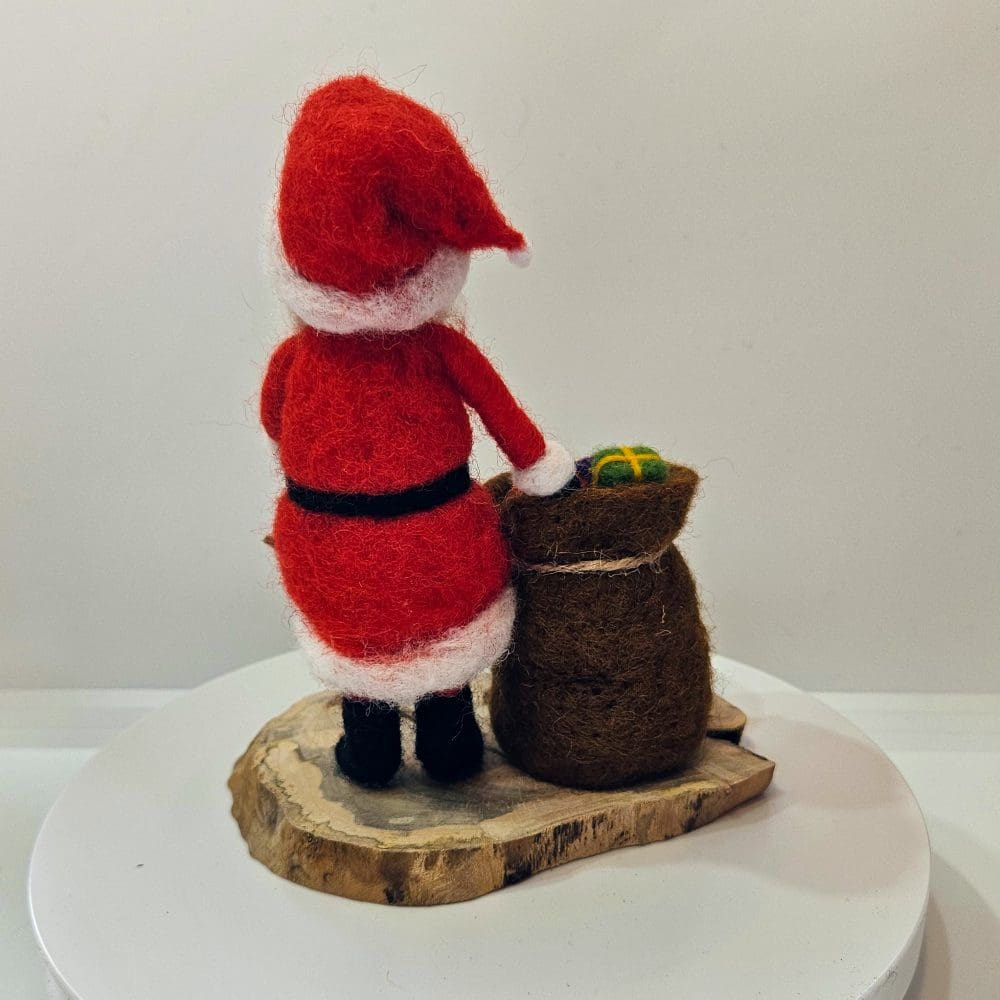 Back view of needle felted Santa figurine with sack of presents