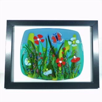 a fused glass floral scene in a picture frame