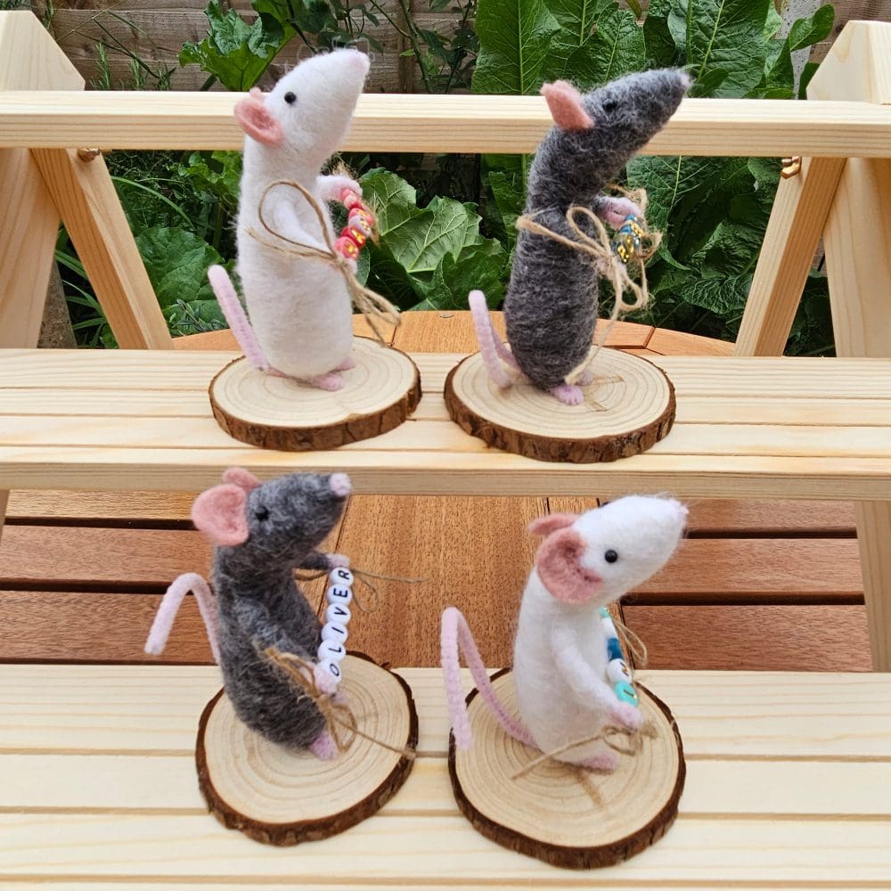 Side view of Needle felted mice holding bead names