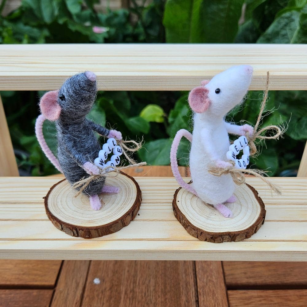 side view of needle felted mice holding well done bead sign