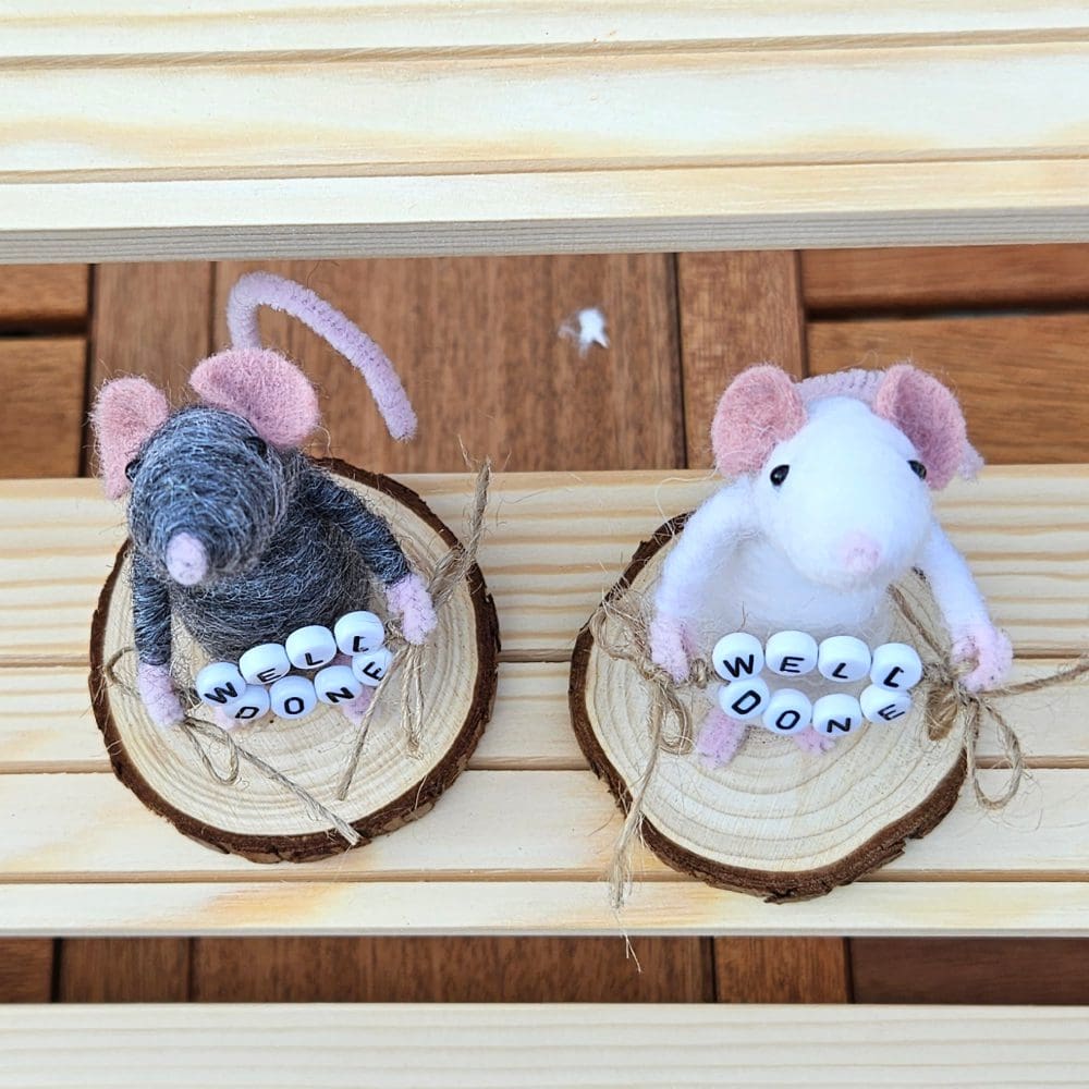 top view of needle felted mice holding well done bead sign