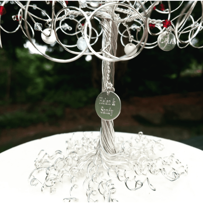 16mm sterling silver disc charm, engraved and attached to the trunk of a silver tree cake topper