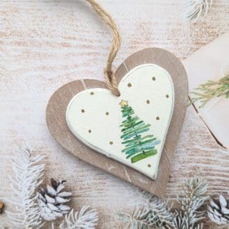 Two layer wooden hanging heart painted white and decoupaged with a Christmas tree surrounded by gold dots. Finished with a natural twine hanger