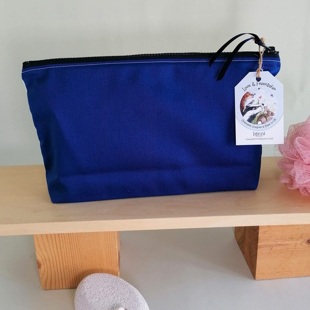 The back of the toiletries bag for the little brown dog is a bright blue cotton and has a chunky plastic zip.