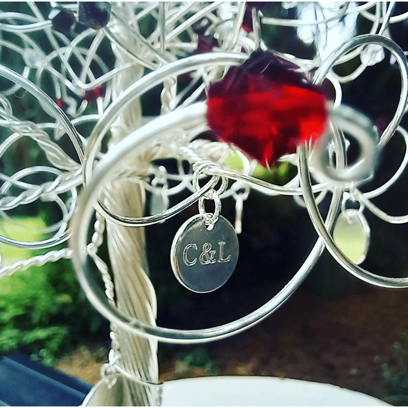 9mm silver charm which has been engraved and added to a tree branch.