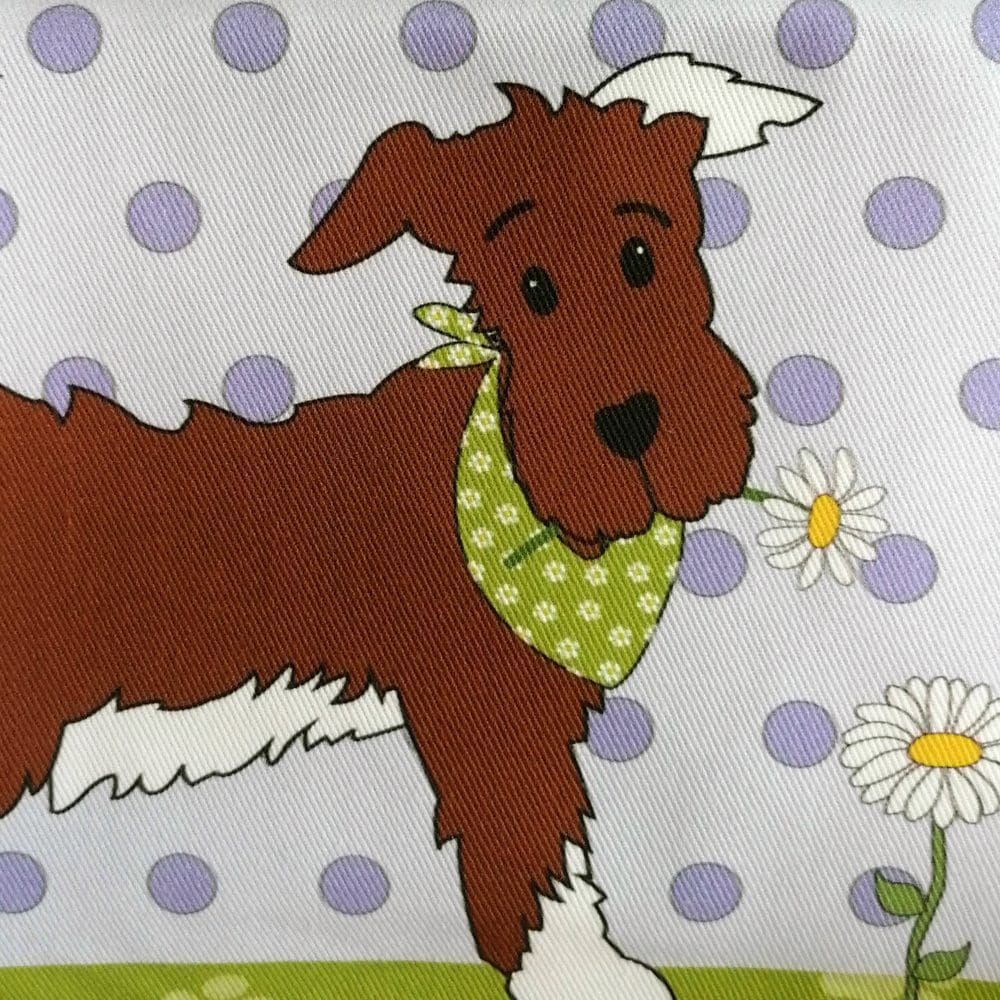Heavyweight cotton fabric printed in vibrant colours detailing the head of the little running dog sporting a bright green flowery bandana and caught picking a white daisy that hangs from his mouth.