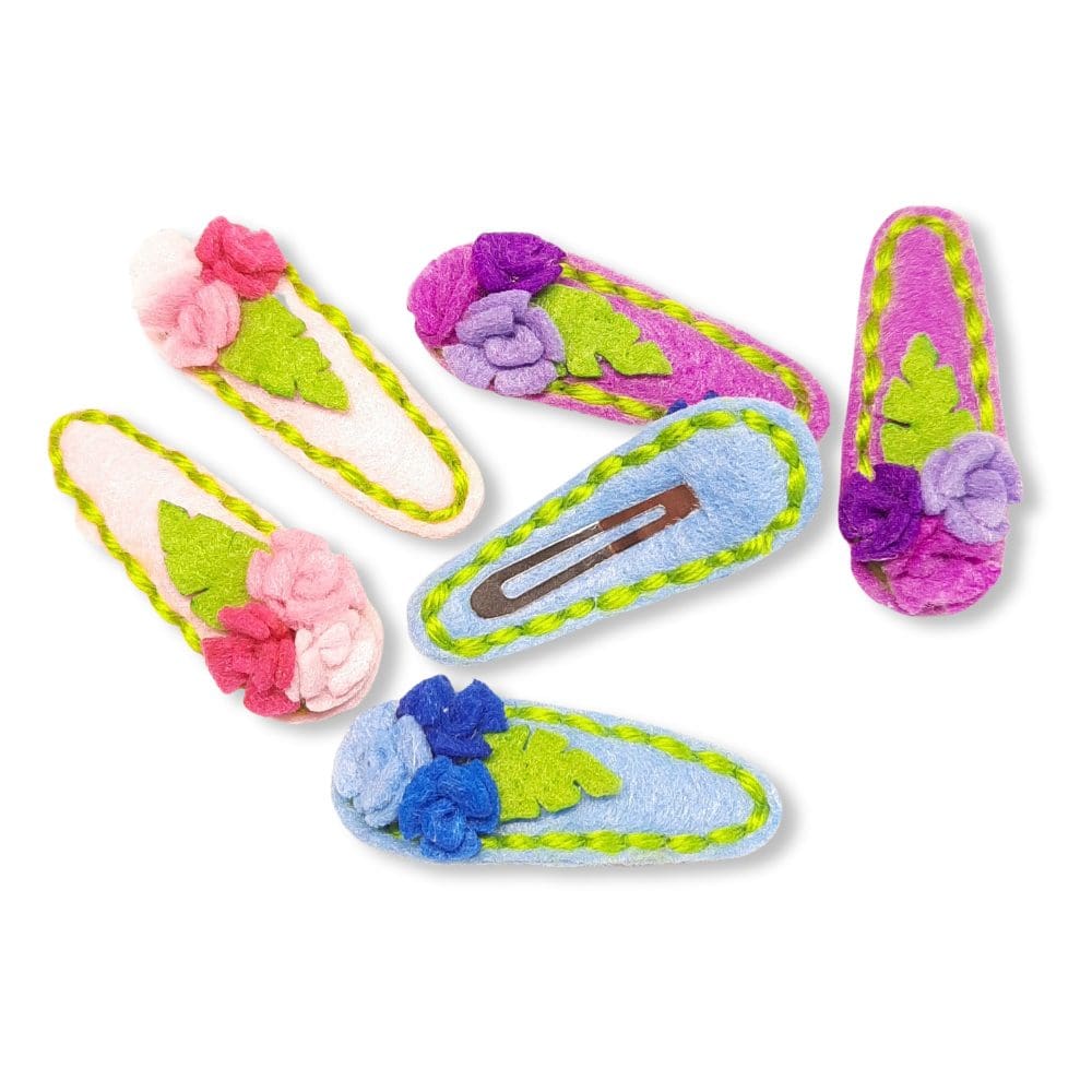 Cute hair clips covered in pink, blue or purple felt with matching roses and stitching. Gentle on delicate hair.