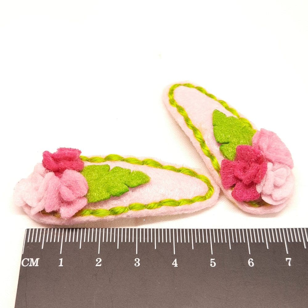 Cute hair clips covered in pink felt with matching roses and stitching. Gentle on delicate hair.